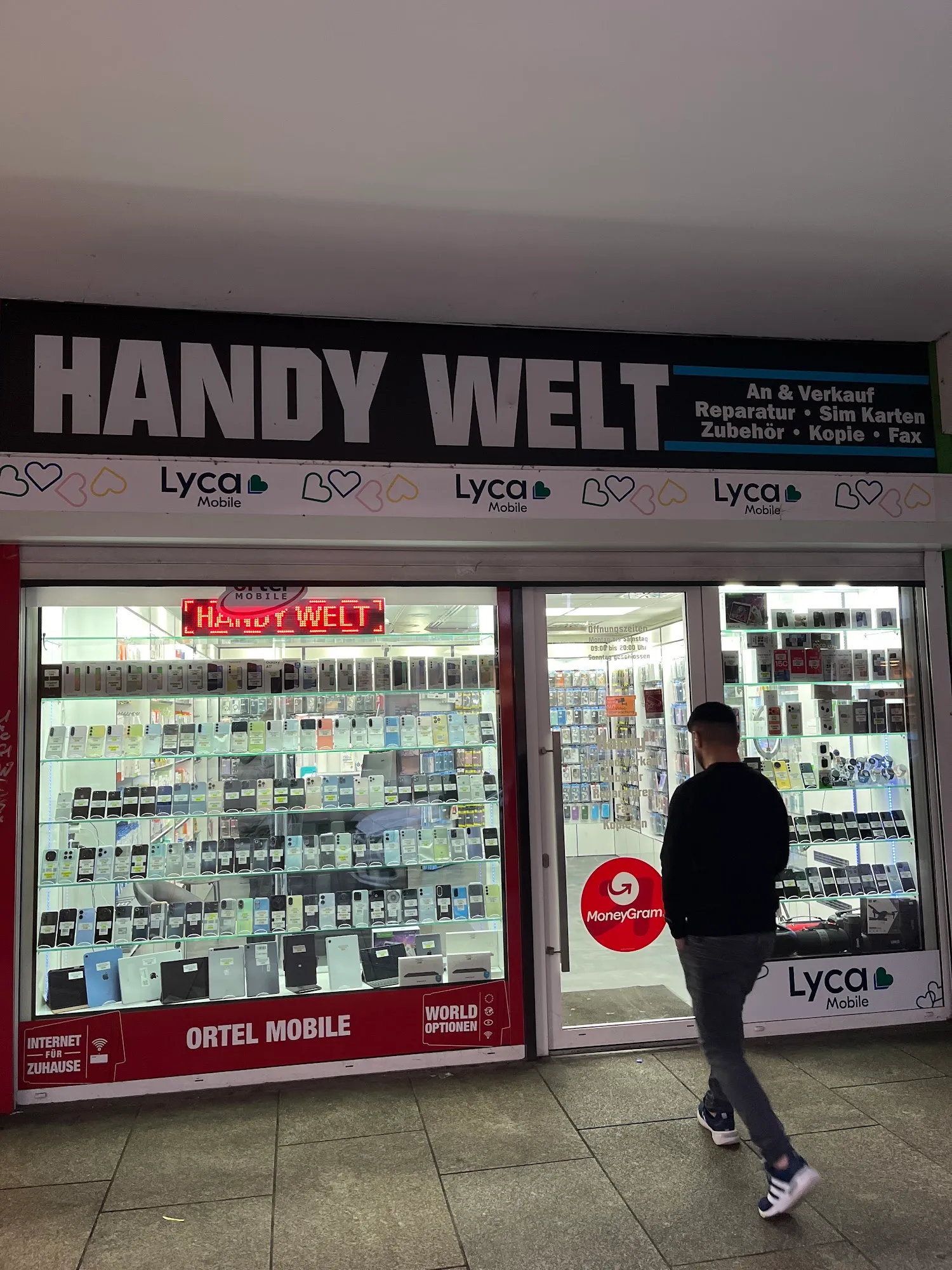 Ladenfront in der Bahnhofstraße mit MoneyGram-Aufkleber und vorbeigehendem Passanten